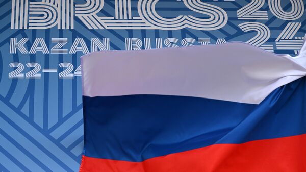 The Russian flag against the background of the BRICS forum logo at the Made in Tatarstan exhibition, held as part of the XVI BRICS summit in Kazan. - Sputnik Afrique