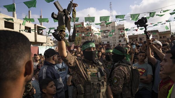 A member of Hamas' military wing raises a rifle seized from Israeli security forces during an arms show for the group at Nusseirat refugee camp, central Gaza Strip, Friday, June 30, 2023 - Sputnik Africa