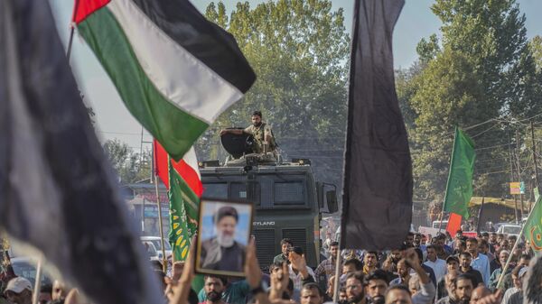 Indian policeman guard as kashmiri Shiite Muslims shout pro-Palestine and anti-Israel slogans during a protest in solidarity with Palestinians and against the killing of Hezbollah leader Hassan Nasrallah, at Mirgund north village of Srinagar, Indian controlled Kashmir, Friday, Oct. 4, 2024. (AP Photo/Mukhtar Khan) - Sputnik Africa