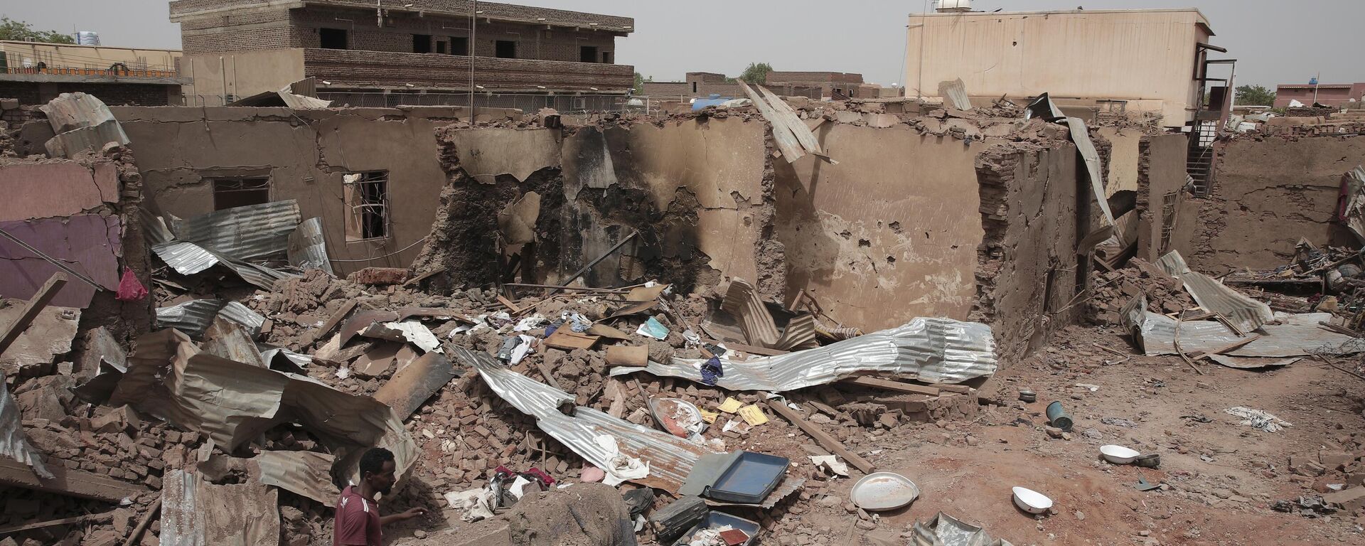 A man walks by a house hit in recent fighting in Khartoum, Sudan, an area torn by fighting between the military and the notorious paramilitary Rapid Support Forces, April 25, 2023.  - Sputnik Africa, 1920, 28.10.2024