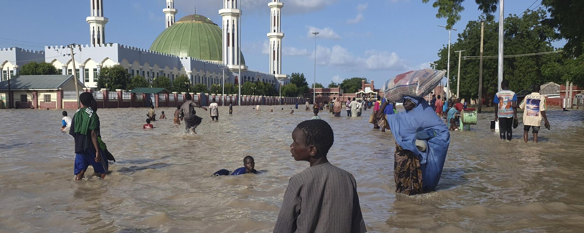 People walk through floodwaters following a dam collapse in Maiduguri, Nigeria, Tuesday, Sept 10, 2024 - Sputnik Africa, 1920, 01.11.2024