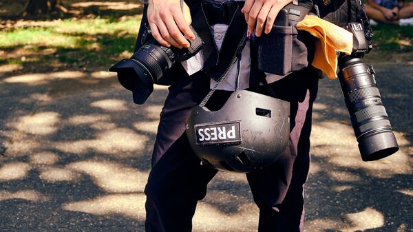 A journalist carrying a press helmet - Sputnik Africa