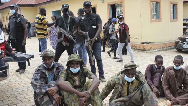 Three men seated on the ground, identified by police officers as kidnappers of The Bethel Baptist High School students, are shown to the media in Abuja, Nigeria. Thursday, Sept. 23, 2021 - Sputnik Africa