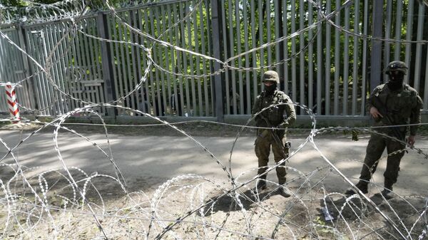 Polish troops guard the metal barrier border with Belarus - Sputnik Africa