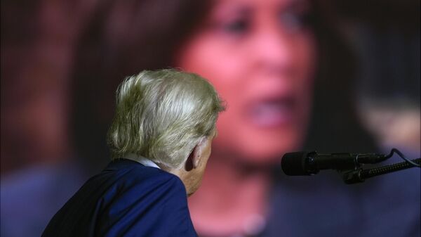 Republican presidential nominee former President Donald Trump watches a video featuring Democratic presidential nominee Vice President Kamala Harris as he speaks at a campaign rally at PPL Center, Tuesday, Oct. 29, 2024, in Allentown, Pa. - Sputnik Afrique