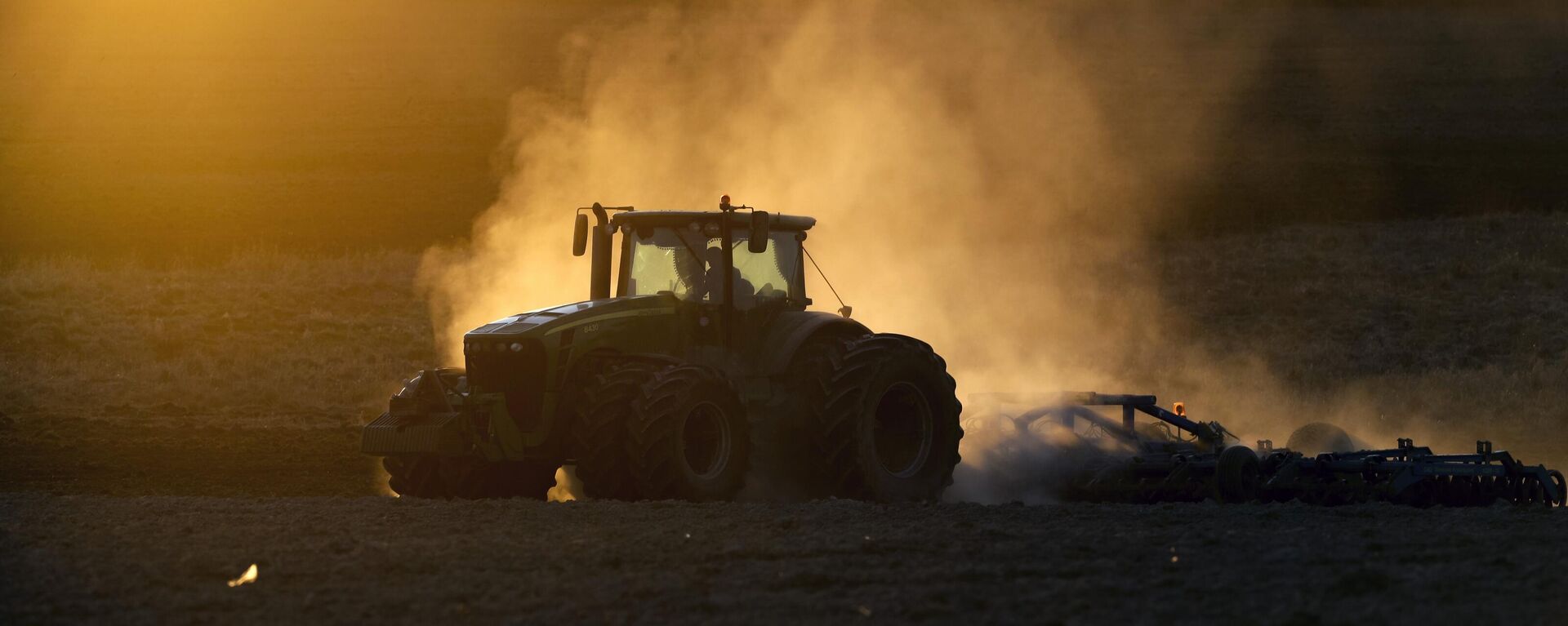 A tractor ploughs the land in a field during a sunset on the outskirts of Minsk, Belarus, Wednesday, April 8, 2020. - Sputnik Africa, 1920, 08.11.2024