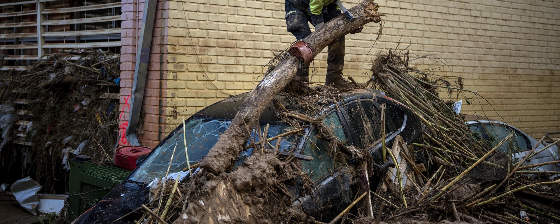 A firefighter removes parts of a tree that fell on cars during the floods in Masanasa, Valencia, Spain, Wednesday, Nov. 6, 2024.  - Sputnik Africa, 1920, 09.11.2024