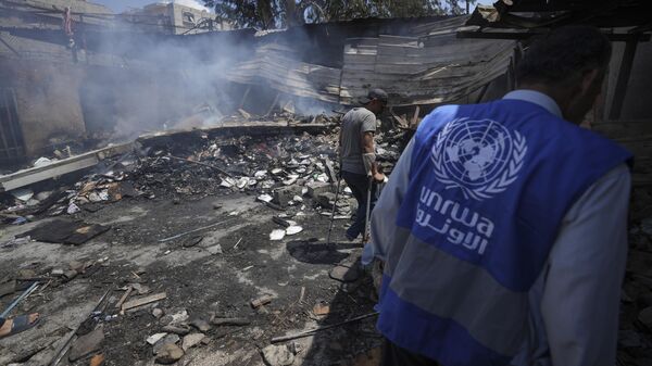 Palestinians look at the destruction after an Israeli strike on a school run by UNRWA, the U.N. agency helping Palestinian refugees, in Nuseirat, Gaza Strip, May 14, 2024. Qatar and Saudi Arabia on Sunday, June 2, 2024 condemned an Israeli parliamentary bill that seeks to label UNRWA, the main provider of aid for Palestinians in Gaza, a terrorist group, joining a growing number of nations opposed to the proposal - Sputnik Africa