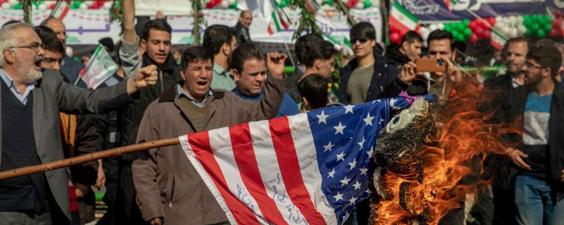 TEHRAN, IRAN - FEBRUARY 11: A US flag is set on fire during the annual rally commemorating Iran's 1979 Islamic Revolution in Tehran, Iran, Sunday, Feb. 11, 2024. Iran marked Sunday the 45th anniversary of the 1979 Islamic Revolution amid tensions gripping the wider Middle East over Israel's continued war on Hamas in the Gaza Strip.  - Sputnik Africa, 1920, 17.11.2024