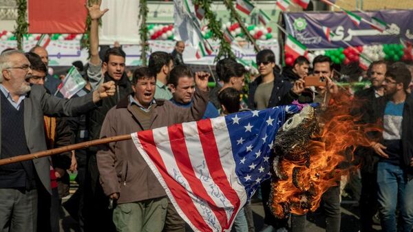 TEHRAN, IRAN - FEBRUARY 11: A US flag is set on fire during the annual rally commemorating Iran's 1979 Islamic Revolution in Tehran, Iran, Sunday, Feb. 11, 2024. Iran marked Sunday the 45th anniversary of the 1979 Islamic Revolution amid tensions gripping the wider Middle East over Israel's continued war on Hamas in the Gaza Strip.  - Sputnik Africa