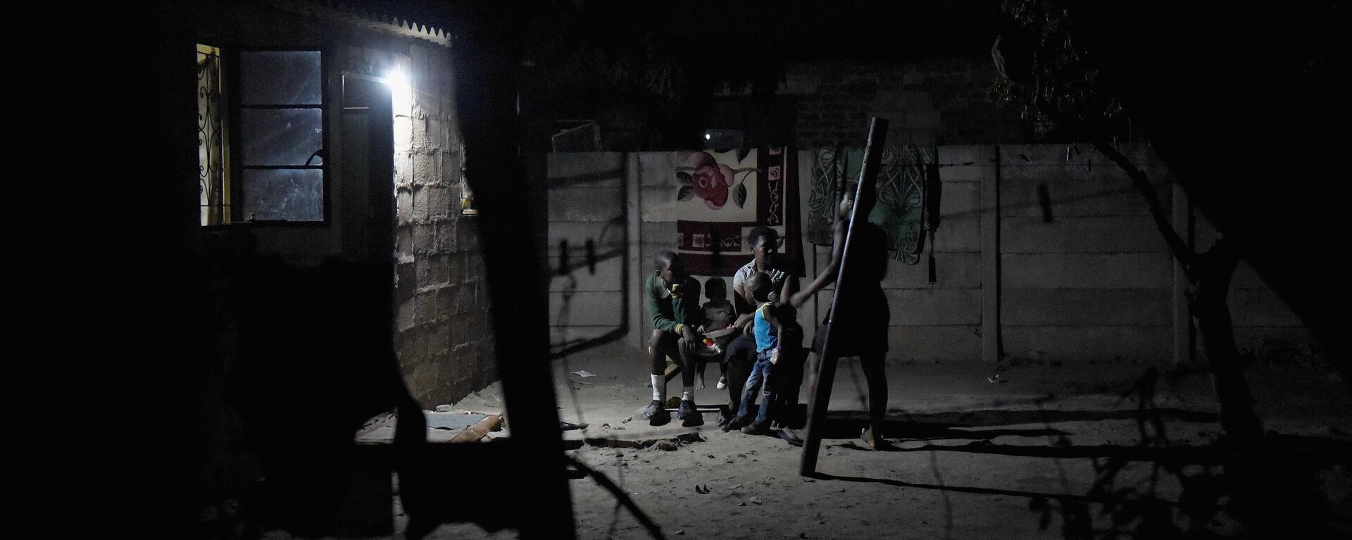 A family sit outside and share food by torchlight, after darkness falls in the Harare suburb of Chitungwiza where electricity is only provided for a few hours, usually after around 9pm, Chitungwiza, Zimbabwe on October 8th 2015. - Sputnik Africa, 1920, 25.11.2024