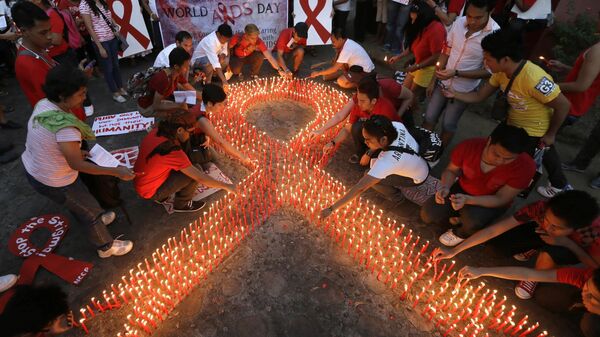 Filipinos light candles which are shaped into an AIDS symbol to mark World AIDS Day Saturday, Dec. 1, 2012 at the Heroes Shrine at suburban Quezon city northeast of Manila, Philippines.  - Sputnik Africa