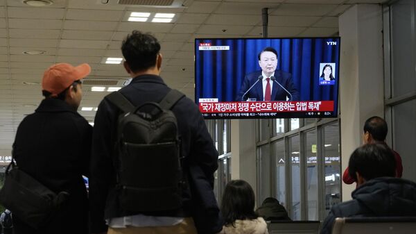 People watch a TV screen showing South Korean President Yoon Suk Yeol's televised briefing at a bus terminal in Seoul, South Korea, Tuesday, Dec. 3, 2024.  - Sputnik Africa