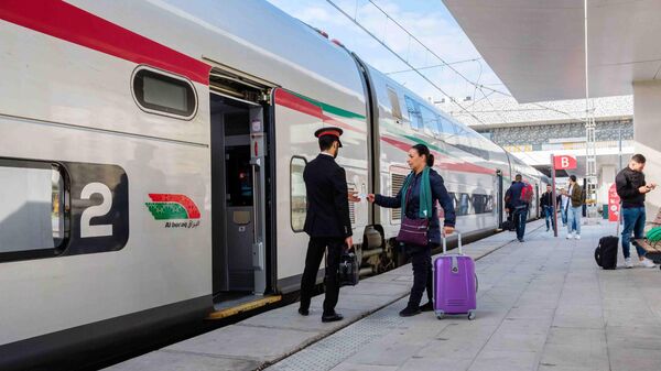 Morocco, Casablanca railway station: TGV high speed train along the platform. Ticket inspector and traveler, woman, in front of a train.  - Sputnik Africa