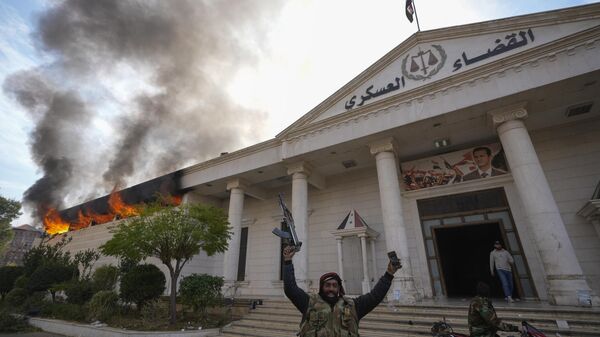 Opposition fighters celebrate as a military court burns in Damascus, Syria, on Sunday, Dec. 8, 2024.  - Sputnik Africa