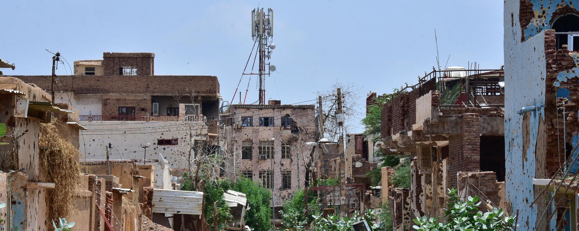 27 August 2024, Sudan, Omdurman: A radio signal tower stands behind houses with bullet holes.  - Sputnik Africa, 1920, 11.12.2024