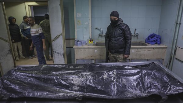 A body lies at the morgue as people stands while waiting to identify missing relatives or friends at the morgue of Al-Mujtahidh hospital in Damascus, Syria, Tuesday, Dec. 10, 2024. - Sputnik Africa