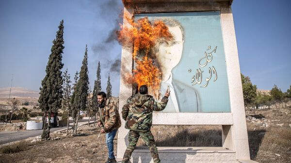 DAMASCUS, SYRIA - 2024/12/10: A man burns a picture of former Syrian president Bashar al-Assad close to Syria's border with Lebanon. Rebels launched a shock offensive across Syria in late November, ousting President Bashar al-Assad and ending more than half a century of the Assad family regime. - Sputnik Africa