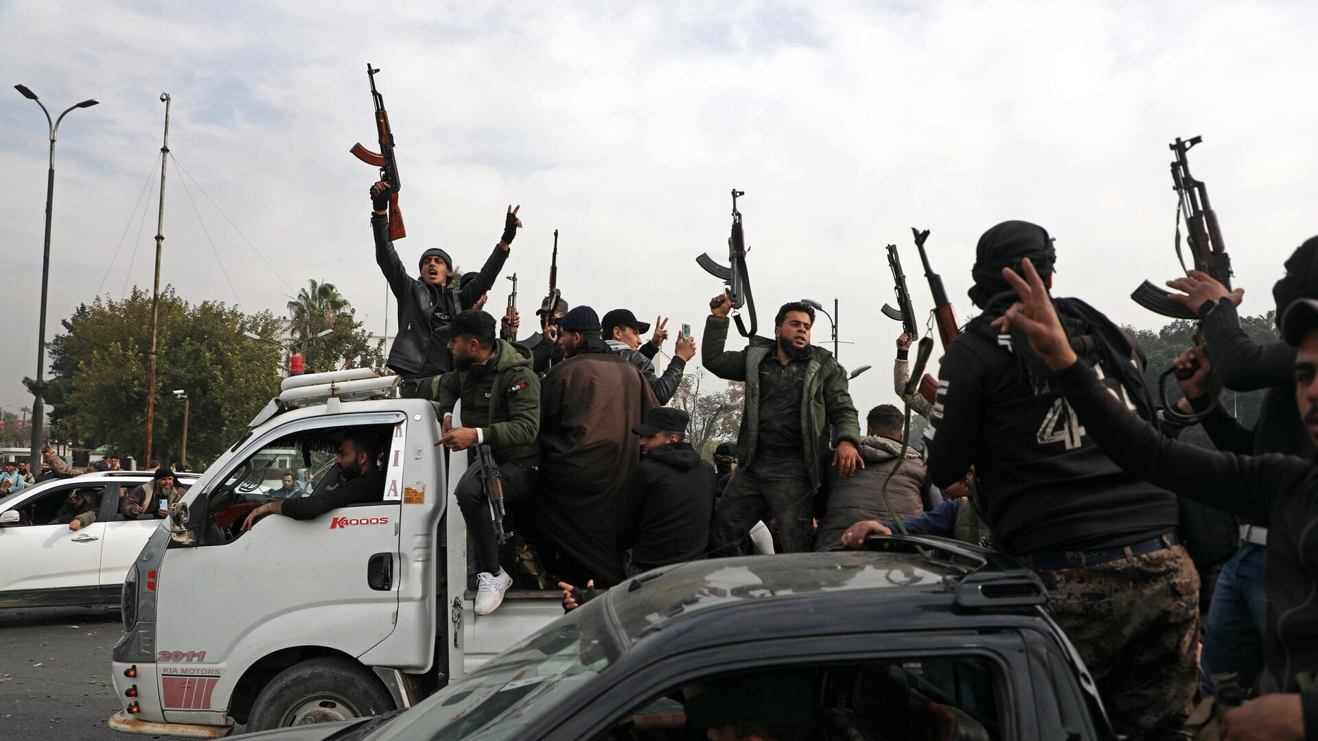 People wave guns in the air, as they gather to celebrate the fall of the Syrian regime in Umayyad Square on December 8, 2024, in Damascus, Syria. - Sputnik Africa, 1920, 12.12.2024