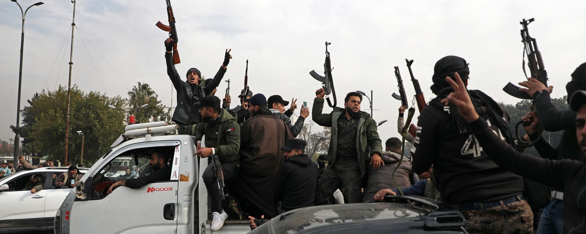 People wave guns in the air, as they gather to celebrate the fall of the Syrian regime in Umayyad Square on December 8, 2024, in Damascus, Syria. - Sputnik Africa, 1920, 12.12.2024