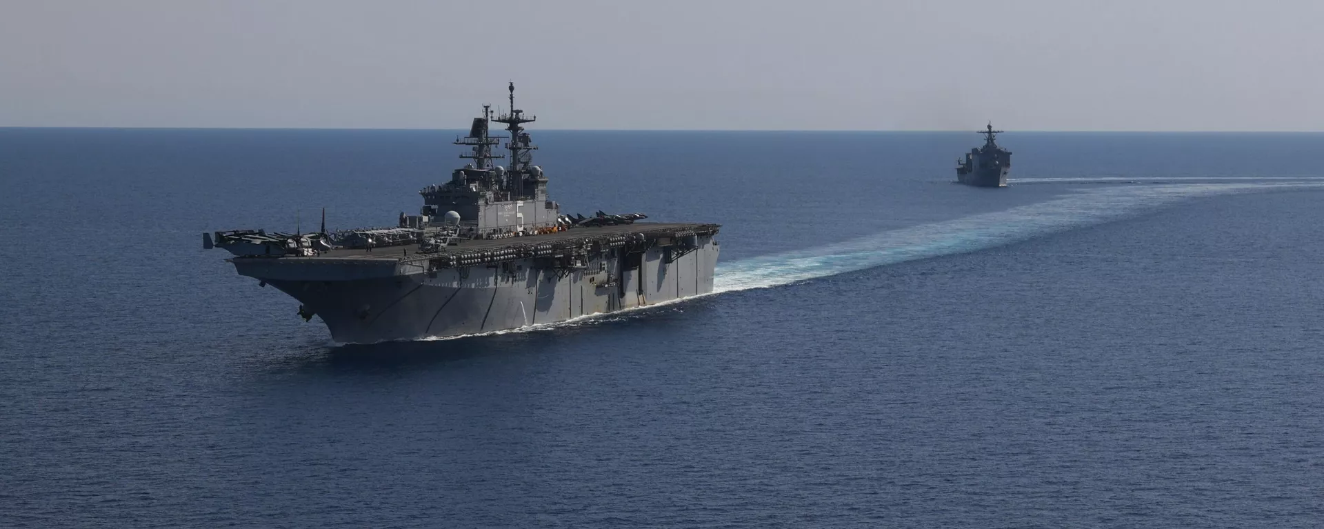 In this photo released by the U.S. Navy, the amphibious assault ship USS Bataan, front, and the landing ship USS Carter Hall, back travel through the Red Sea - Sputnik Africa, 1920, 17.12.2024