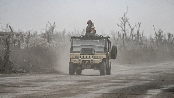 Russian servicemen drive a vehicle in the village of Karlovka, controlled by Russian armed forces, near Krasnoarmeysk  - Sputnik Africa