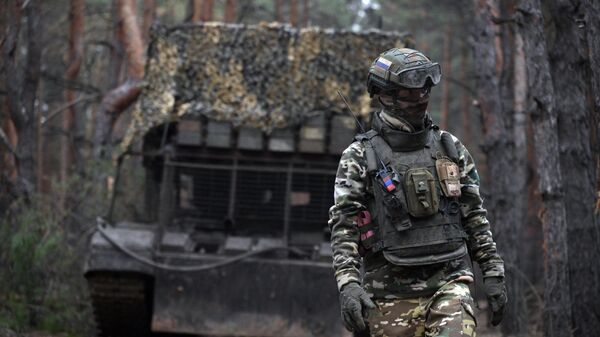 A Russian serviceman walks next to the TOS-1A Solntsepyok thermobaric rocket launcher at a position amid Russia's military operation. - Sputnik Africa