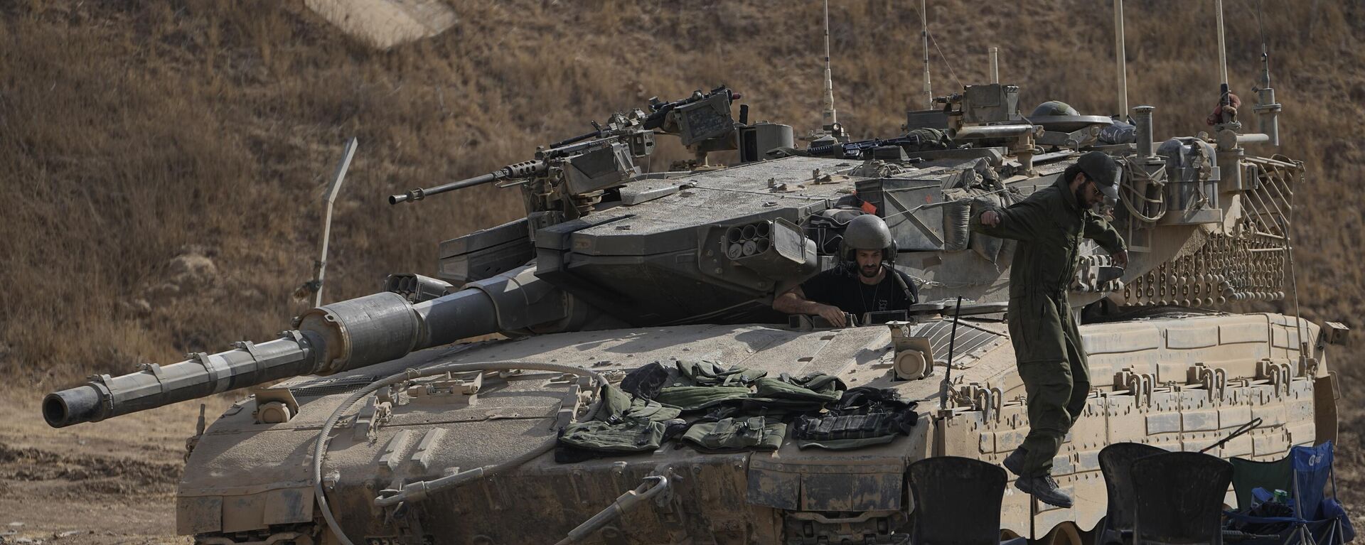 An Israeli soldier jumps from the top of a tank in an area near the Israeli-Gaza border, seen from southern Israel, Wednesday, July 24, 2024.  - Sputnik Africa, 1920, 25.12.2024