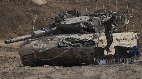 An Israeli soldier jumps from the top of a tank in an area near the Israeli-Gaza border, seen from southern Israel, Wednesday, July 24, 2024.  - Sputnik Africa