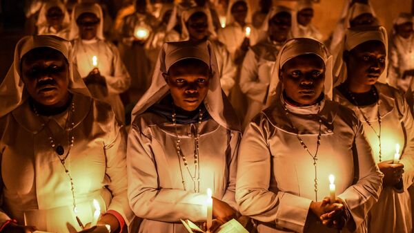 Hundreds of Legio Maria Church members, wearing colourful clothes, gather to pray and light candles at the church in the town with the Christmas Eve celebrations in the town of Mathare in Nairobi, Kenya on December 24, 2024.  - Sputnik Africa