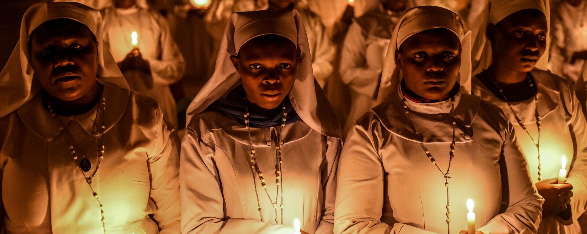 Hundreds of Legio Maria Church members, wearing colourful clothes, gather to pray and light candles at the church in the town with the Christmas Eve celebrations in the town of Mathare in Nairobi, Kenya on December 24, 2024.  - Sputnik Africa, 1920, 26.12.2024