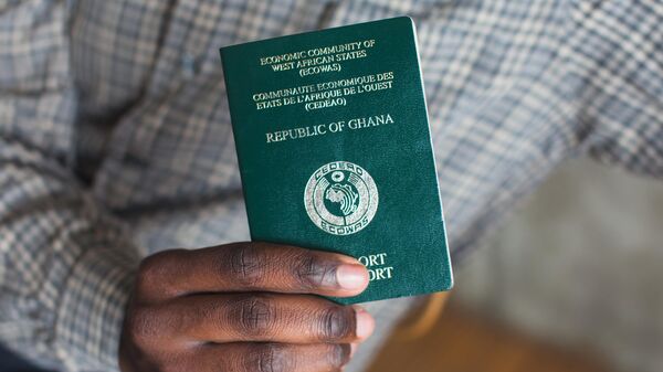 An African man holding a passport from Ghana - Sputnik Africa