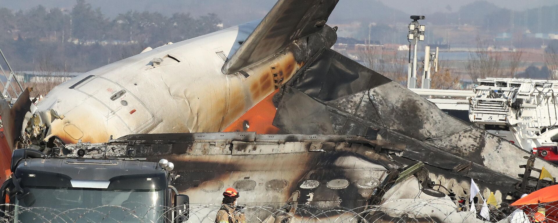 Firefighters check near the wreckage of a passenger plane at Muan International Airport on December 29, 2024 in Muan-gun, South Korea.  - Sputnik Africa, 1920, 29.12.2024