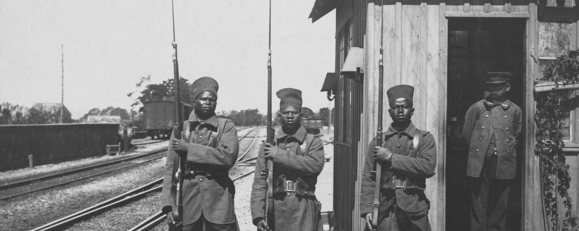 Three African soldiers from a unit of Bataillon Tirailleurs Sénégalais (Senegalese Riflemen) from the L'Infanterie Coloniale (Colonial Infantry) of the French Army present arms with their Lebel Model 1886/93 rifles and bayonets (the soldier in the center carries the Berthier Mle 1907/15 Rifle) whilst on guard duty at a railway station in France circa June 1915.  - Sputnik Africa, 1920, 01.01.2025