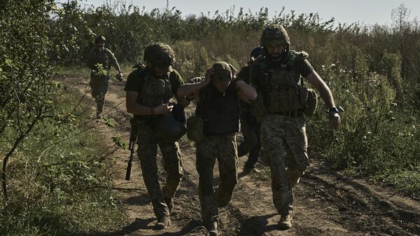 Ukrainian servicemen help to evacuate a wounded soldier on Aug. 30, 2023.  - Sputnik Africa