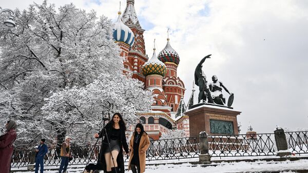 Tourists take pictures against the backdrop of the Pokrovsky Cathedral (St. Basil's Cathedral). - Sputnik Africa