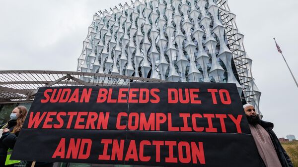 Sudan solidarity activists hold a large sign during a Hands Off Sudan rally outside the US embassy on 9th November 2024 in London, United Kingdom. - Sputnik Africa