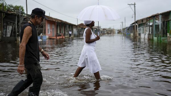 Residents wade through a flooded street after Hurricane Rafael passed through Batabano, Cuba, Thursday, Nov. 7, 2024.  - Sputnik Africa