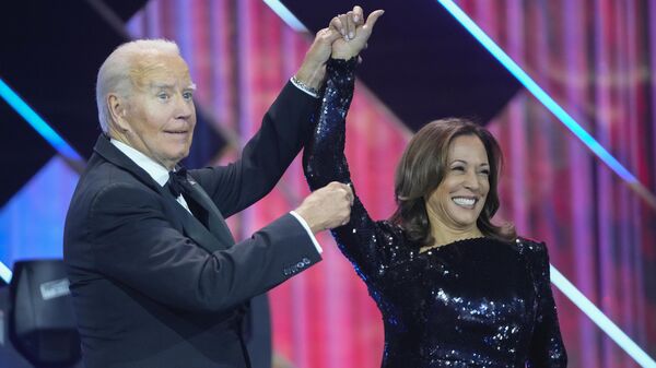 President Joe Biden, left, holds up the arm of Democratic presidential nominee Vice President Kamala Harris, right, while on stage at the Congressional Black Caucus Foundation's Phoenix Awards Dinner in Washington, Saturday, Sept. 14, 2024.  - Sputnik Africa