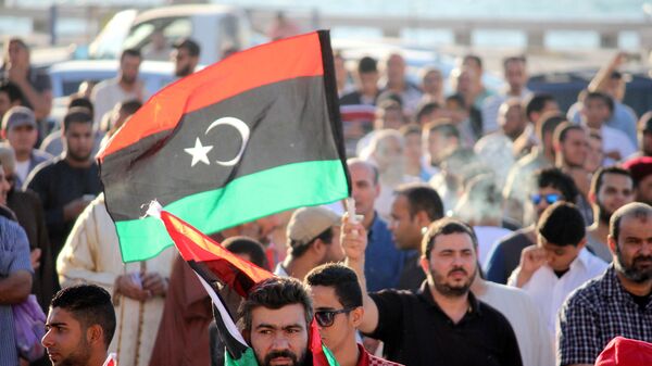 A libyan holds national flag during the protest against the newly elected parliament on August 8, 2014 in Benghazi, Libya.  - Sputnik Africa