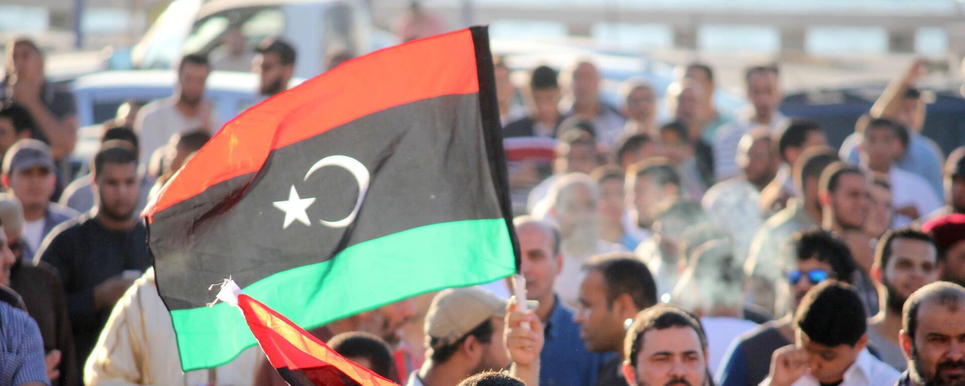 A libyan holds national flag during the protest against the newly elected parliament on August 8, 2014 in Benghazi, Libya.  - Sputnik Africa, 1920, 08.01.2025