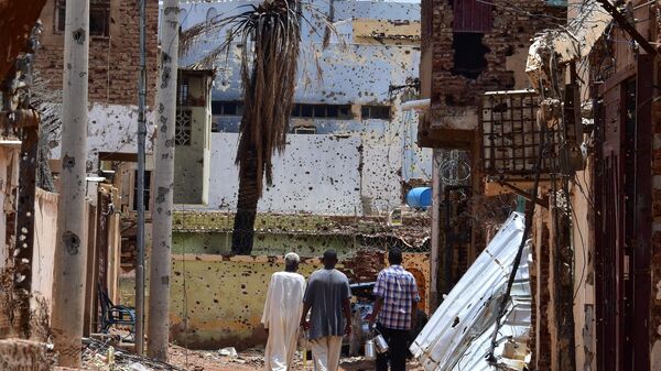 27 August 2024, Sudan, Omdurman: Three men walk through a street marked by destruction towards a mosque.  - Sputnik Africa