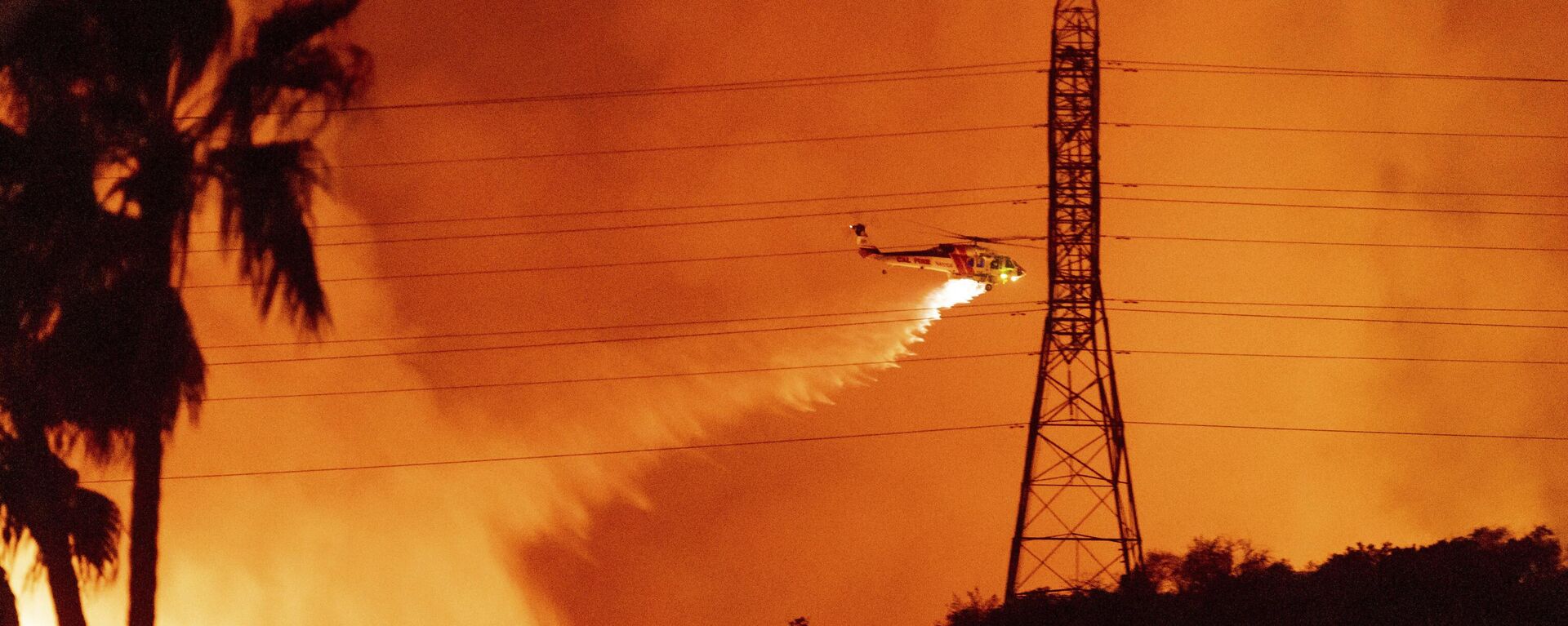 A helicopter drops water on the Palisades Fire in Mandeville Canyon, Friday, Jan. 10, 2025, in Los Angeles.  - Sputnik Africa, 1920, 11.01.2025