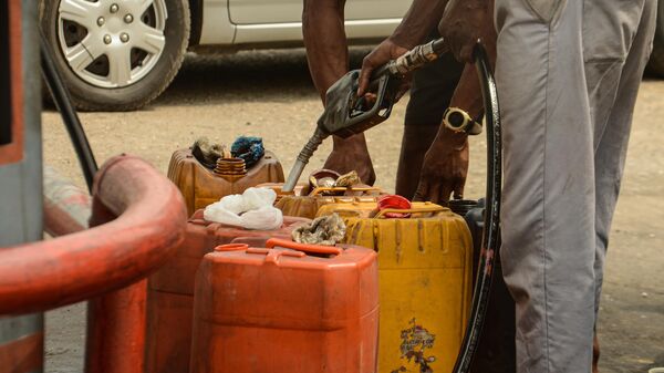 An attendant pumps fuel into jerrycans at FATGBEMS filling station in Lagos, Nigeria, 08 February 2022.  - Sputnik Africa