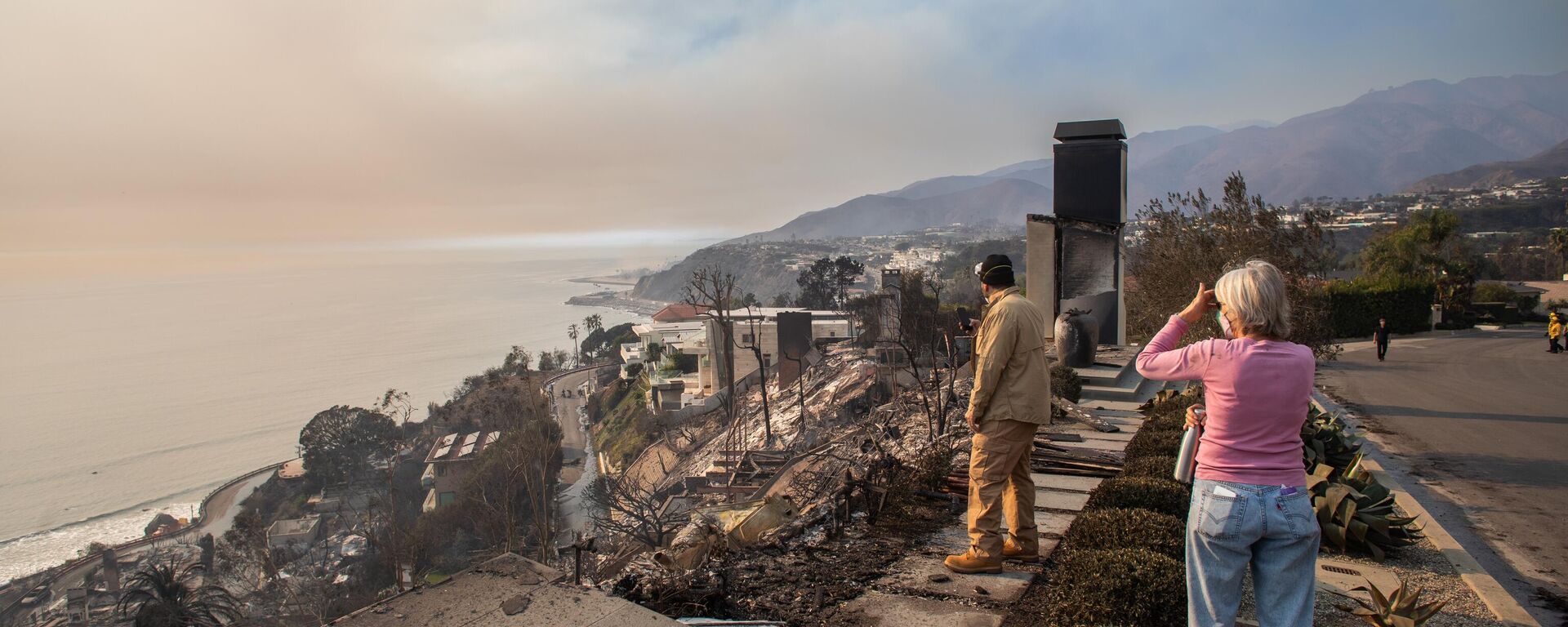 People look at homes burned in the Palisades Fire in Los Angeles, California. - Sputnik Africa, 1920, 11.01.2025