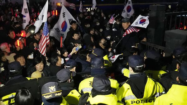 Police officers stand guard as supporters of impeached South Korean President Yoon Suk Yeol try to enter the Seoul Western District Court in Seoul, South Korea, Saturday, Jan. 18, 2025.  - Sputnik Africa