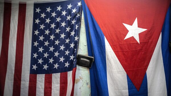 A US and Cuban flags hang from a wall with an old photo camera hung in between in Havana, Cuba, Monday, Jan 11, 2021.  - Sputnik Africa