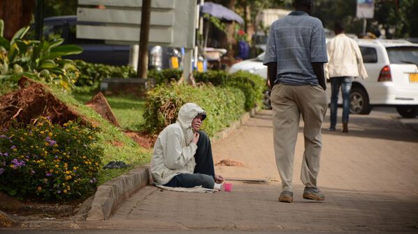 A man walks past an albino beggar along Kijabe Street in Nairobi, Kenya - Sputnik Africa