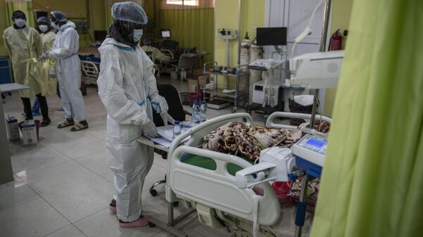 Health workers wearing personal protective equipment tend to a patient at the Covid-19 ward of Jabra Central Hospital on January 28, 2021 in Khartoum, Sudan.  - Sputnik Africa