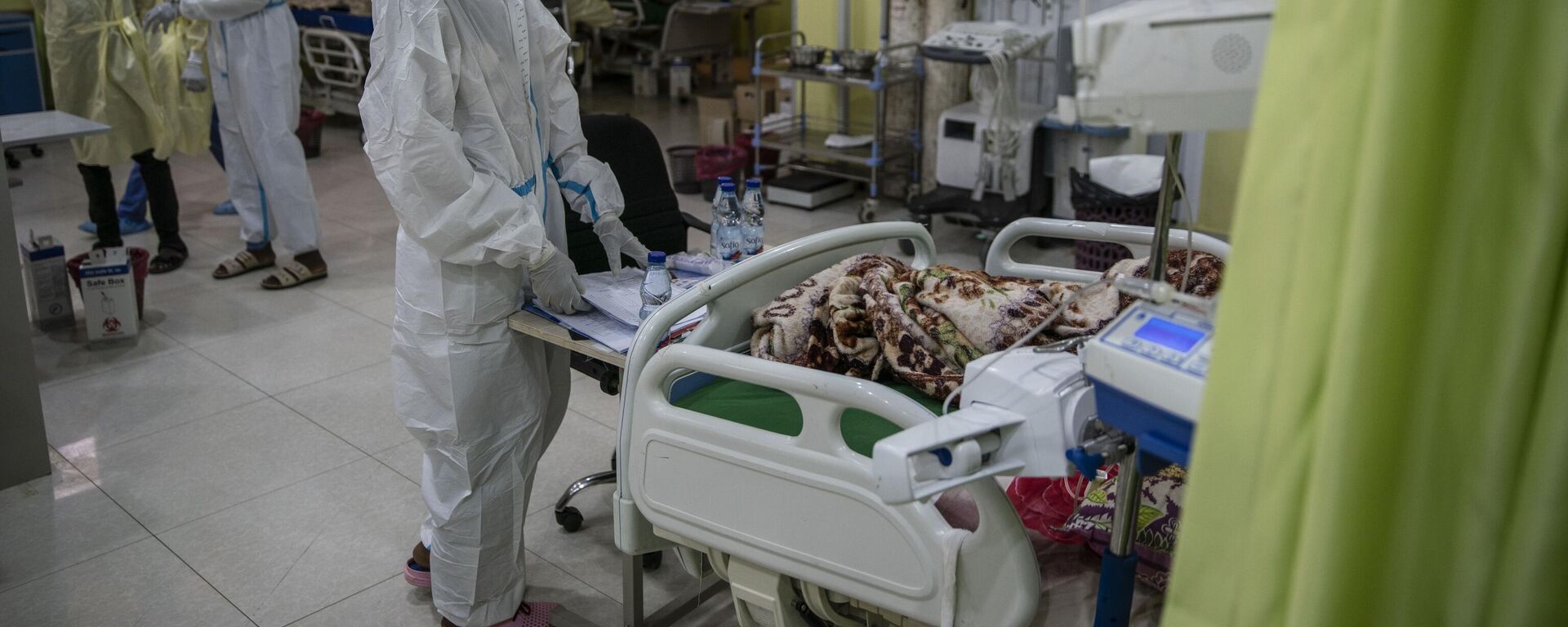 Health workers wearing personal protective equipment tend to a patient at the Covid-19 ward of Jabra Central Hospital on January 28, 2021 in Khartoum, Sudan.  - Sputnik Africa, 1920, 26.01.2025